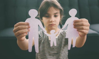 Elinde kağıttan bir aile olan bir çocuk. Boşanma, velayet ve çocuk istismarı kavramı. Seçici odaklanma. İnsanlar.