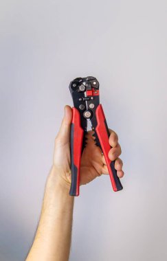 İzole edilmiş bir erkek ellerindeki elektrikli pense. Seçici odaklanma. İnsanlar.