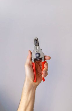 İzole edilmiş bir erkek ellerindeki elektrikli pense. Seçici odaklanma. İnsanlar.