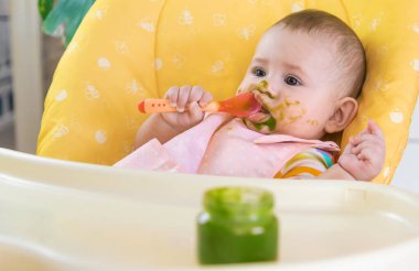 Küçük bebek brokoli sebze püresi yiyor. Seçici odaklanma. İnsanlar.