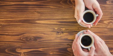 Kadın ve erkeklerin elinde kahve bardakları..