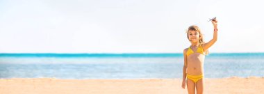 Kumsalda elinde uçaklar olan bir çocuk. Seçici odaklanma. tatiller.