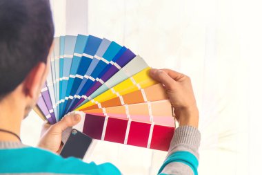 Paletteki boyanın rengini seçmek için tamir işi. Seçici odaklanma. İnsanlar.