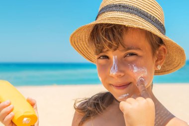 Bir çocuğun teninde güneş kremi. Seçici odaklanma. Doğa.