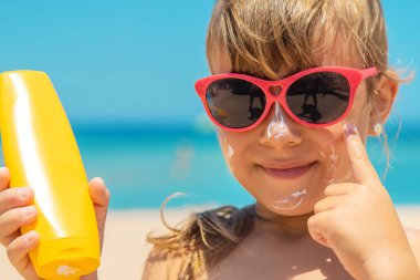 Bir çocuğun teninde güneş kremi. Seçici odaklanma. Doğa.