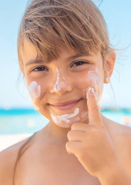 Bir çocuğun teninde güneş kremi. Seçici odaklanma. Doğa.