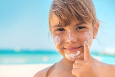 Bir çocuğun teninde güneş kremi. Seçici odaklanma. Doğa.