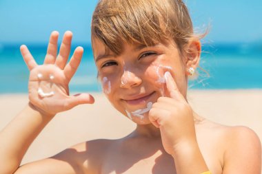 Bir çocuğun teninde güneş kremi. Seçici odaklanma. Doğa.