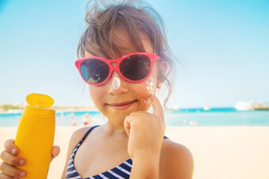 Bir çocuğun teninde güneş kremi. Seçici odaklanma. Doğa.