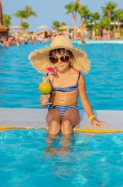 Havuzun yanında kokteyl içen bir kız çocuğu. Seçici odaklanma. Yiyecek..