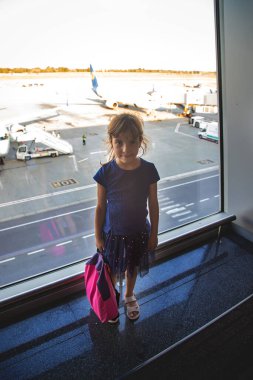 Havaalanındaki bir kız çocuğu uçaklara bakıyor. Seçici odaklanma. Çocuk.