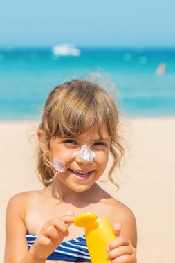 Bir çocuğun teninde güneş kremi. Seçici odaklanma. Doğa.