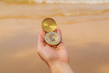 Deniz ve sahilin arka planında pusula var. Seçici odaklanma. seyahat.