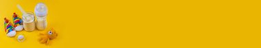 Sarı arka planda bebek sütü ve aksesuarları. Seçici odaklanma. yiyecek.