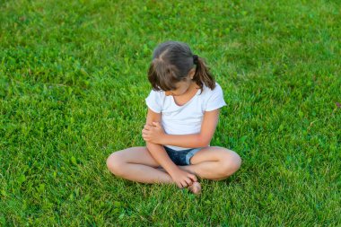 Çocuk sivrisinekler tarafından ısırılır. Seçici odaklanma. Doğa.