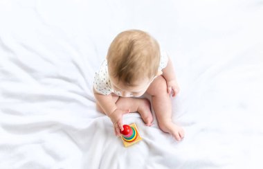 Bebek evde bir piramitle oynuyor. Seçici odaklanma. İnsanlar.