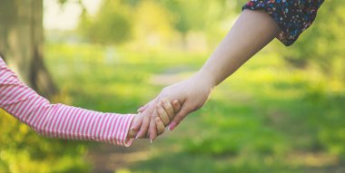 Annesiyle birlikte bir çocuk ellerinden tutar. Seçici odaklanma. Doğa.