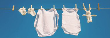 Beyaz bebek kıyafetleri iple kurumuş. Seçici odaklanma. Doğa.