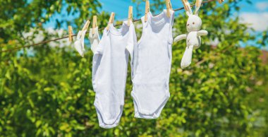 Beyaz bebek kıyafetleri iple kurumuş. Seçici odaklanma. Doğa.