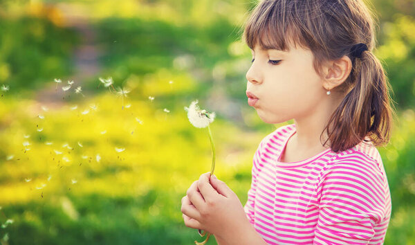 Child girl with dandelions in the park. Selective focus.