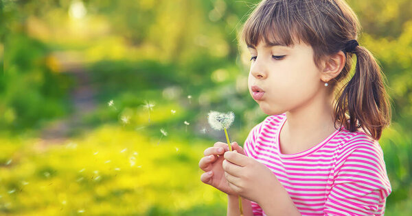 Child girl with dandelions in the park. Selective focus.