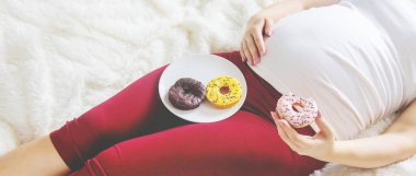 Hamile bir kadın tatlı çörekler yer. Seçici Odaklanma. Yiyecek..