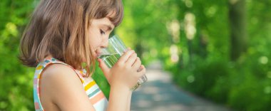 Bir çocuk doğadaki bir bardaktan su içer. Seçici odaklanma. İç..