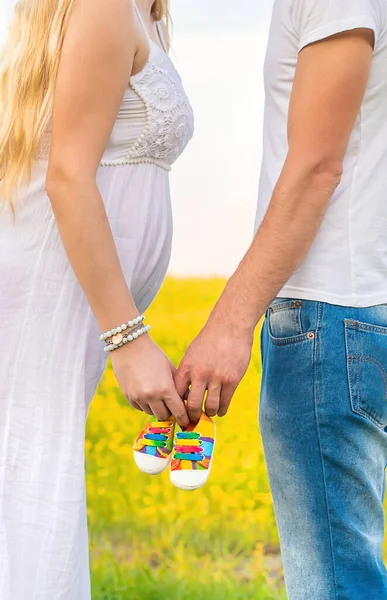 Mujer Embarazada Hombre Sostienen Zapatos Bebé Enfoque Selectivo Naturaleza — Foto de Stock