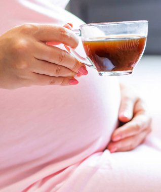 Hamile bir kadın kahve içiyor. Seçici odaklanma. insanlar.