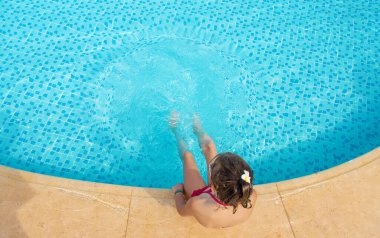 Çocuk havuza su sıçratıyor. Seçici odaklanma. İnsanlar.