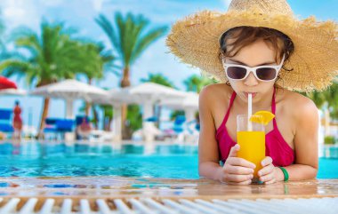 Çocuk havuz kenarında bir kokteyl içiyor. Seçici odaklanma. Çocuk.