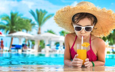 Çocuk havuz kenarında bir kokteyl içiyor. Seçici odaklanma. Çocuk.