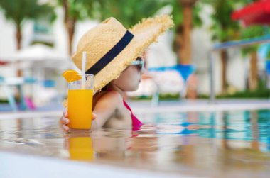 Çocuk havuz kenarında bir kokteyl içiyor. Seçici odaklanma. Çocuk.