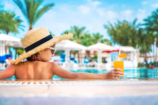 Çocuk havuz kenarında bir kokteyl içiyor. Seçici odaklanma. Çocuk.