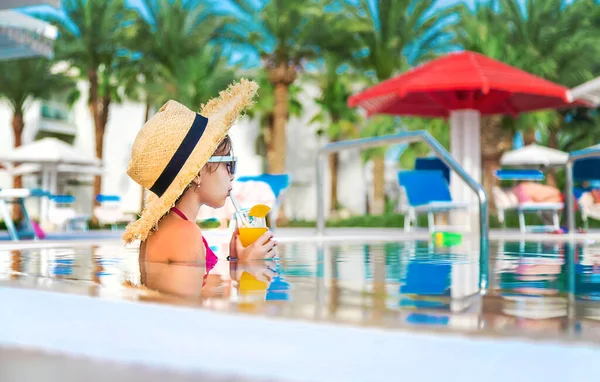 Çocuk havuz kenarında bir kokteyl içiyor. Seçici odaklanma. Çocuk.