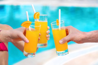 Havuz kenarındaki ailenin elinde kokteyl var. Seçici odaklanma. İnsanlar.