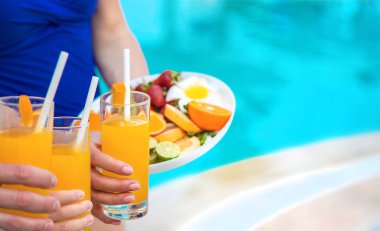 Havuz kenarındaki ailenin elinde kokteyl var. Seçici odaklanma. İnsanlar.