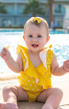 Havuzun yanındaki bebek suyla kaplanmış. Seçici odaklanma. İnsanlar.