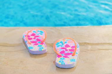 Havuzun yanında kadın terlikleri. Seçici odaklanma. Deniz.