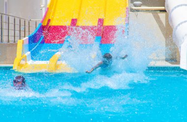 Çocuklar su parkındaki slaytlardan inerler. Seçici odaklanma. Doğa.