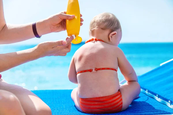 Mother puts sunscreen on baby. Selective focus. Child.