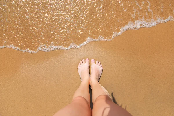 女人的腿在海边靠近大海的地方有选择的重点 — 图库照片