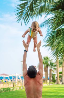 Bebek ve baba çocuğu atar. Seçici odaklanma. Doğa.