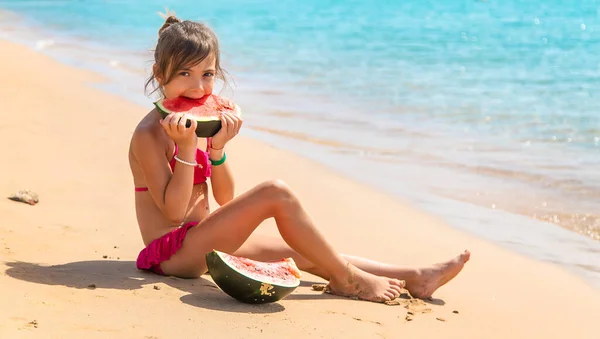 소녀는 바닷가에서 수박을 먹습니다 선택적 집중입니다 어린이 — 스톡 사진