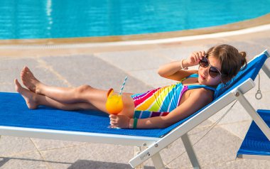 Çocuk havuz kenarında bir kokteyl içiyor. Seçici odaklanma. Çocuk.