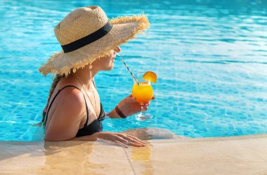 Havuzda kokteyl içen kadın. Seçici odaklanma. İç..