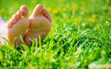 Çimlerin üzerinde çocuk ayakları. Seçici odaklanma. Çocuk.