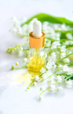 Vadideki zambak, küçük bir şişede gerekli yağ. Seçici odaklanma. Doğa.