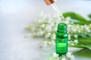 Vadideki zambak, küçük bir şişede gerekli yağ. Seçici odaklanma. Doğa.