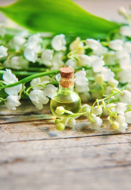 Vadideki zambak, küçük bir şişede gerekli yağ. Seçici odaklanma. Doğa.